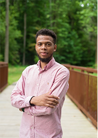 Assistant Professor Quentin Sanders poses for a headshot in front of GMU's outdoor bridge